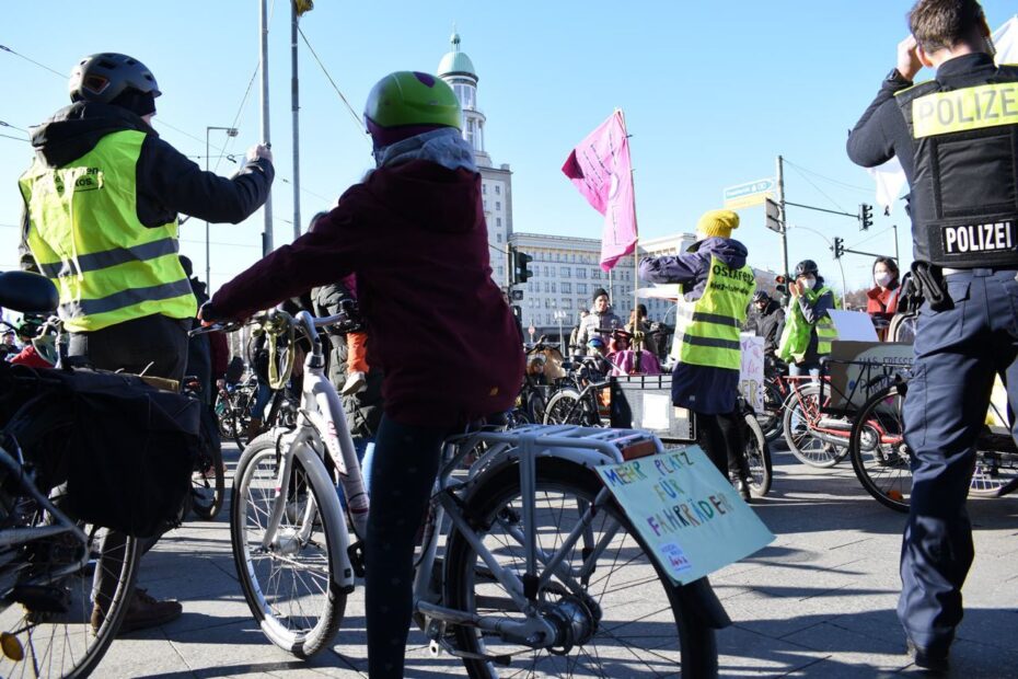 Kinder auf dem Fahrrad draußen auf der Fahrrad-Demo, Plakate und Fahnen, sowie das Frankfurter Tor im Hintergrund